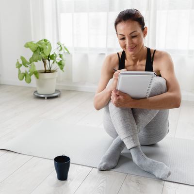 Midlife Woman Sat On Floor Writing