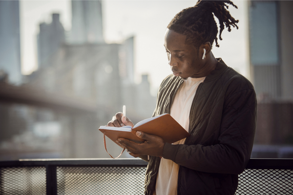 Girl Writing In Journal On Balcony